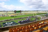 A picture of a horse racing course taken from the grandstand.