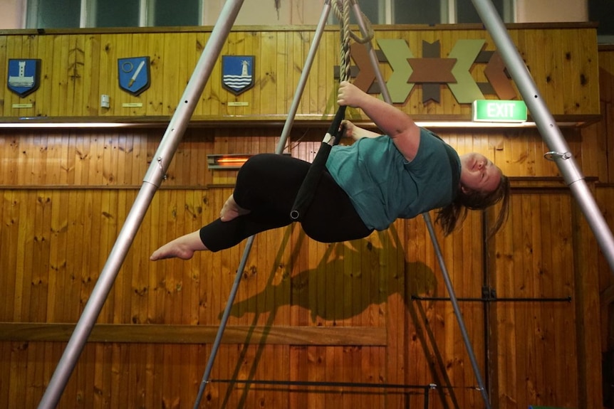 A young girl practicing trapeze at the Lolly Jar Circus