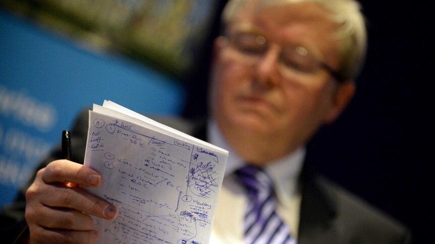 Kevin Rudd checks his notes during a debate at Colmslie Hotel in Brisbane.