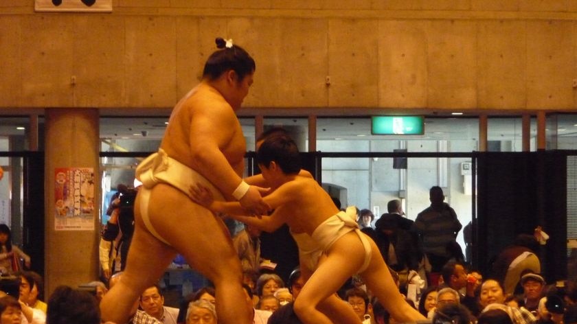 A sumo wrestler clowns around with a youngster at a tournament in Tokyo.