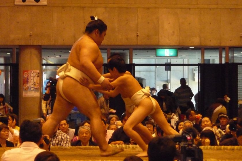 A sumo wrestler clowns around with a youngster at a tournament in Tokyo.