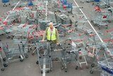 City of Marion Mayor Kris Hanna stands with 232 shopping trolleys.