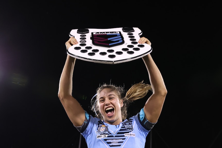 NSW Sky Blues captain Kezie Apps holds up the Women's State of Origin shield.