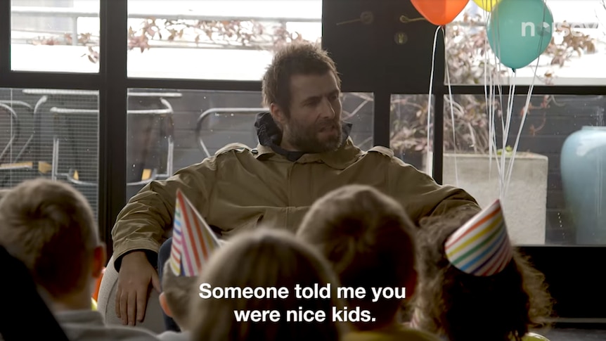 A shot of Liam Gallagher saying "someone told me you were nice kids" to a room of grade-schoolers