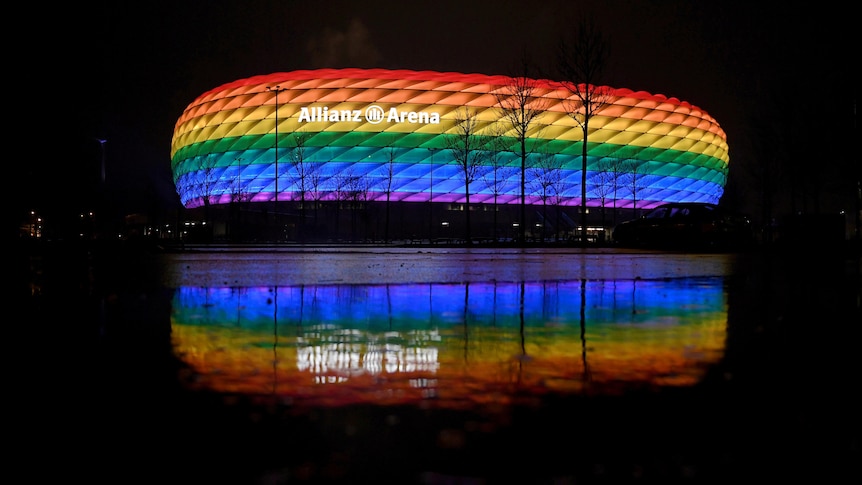 Photo of a stadium lit up with rainbow colours