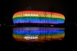 Photo of a stadium lit up with rainbow colours
