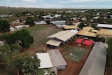 Aerial view of school buildings and grounds in a remote town.