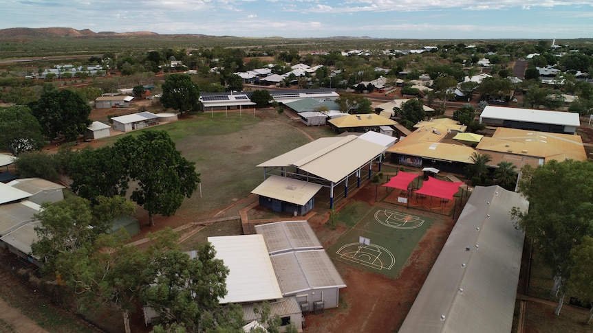 Aerial view of school buildings and grounds in a remote town.