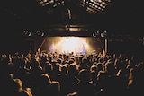 A band on stage at music venue The Zoo in Brisbane with a large crowd watching them perform