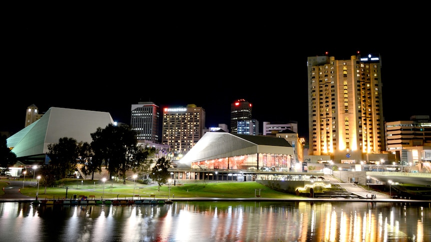 Adelaide Festival Centre lit up at night, viewed from across the water.
