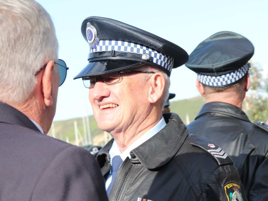 A smiling policeman in uniform with glases