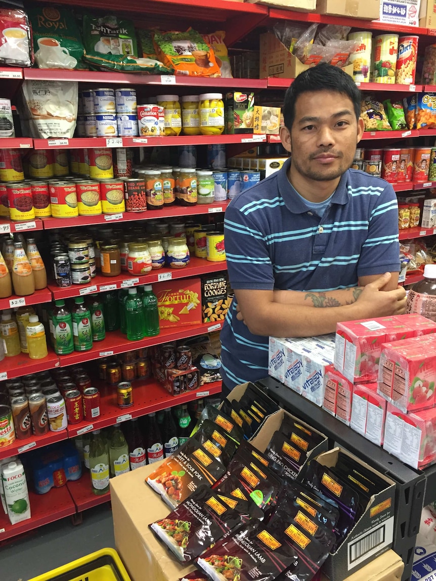 Phillip Kyaw stands in front of his supermarket stock