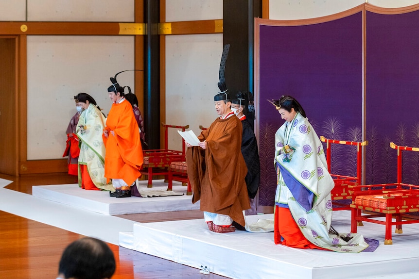 Japan's Crown Prince Akishino, in orange robe, flanked by his wife Crown Princess Kiko, second from left, during a ceremony.