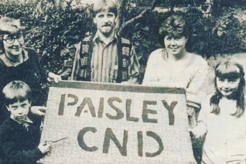 A black and white photo of three adults and two children holding a banner that says 'Paisley CND'.