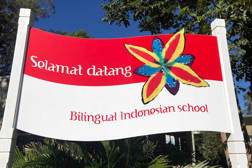 A red and white sign saying 'welcome' in Bahasa Indonesia