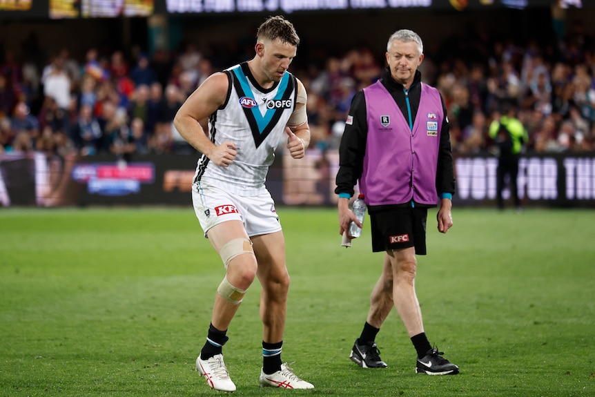 An AFL player performs a fitness test on the pitch.