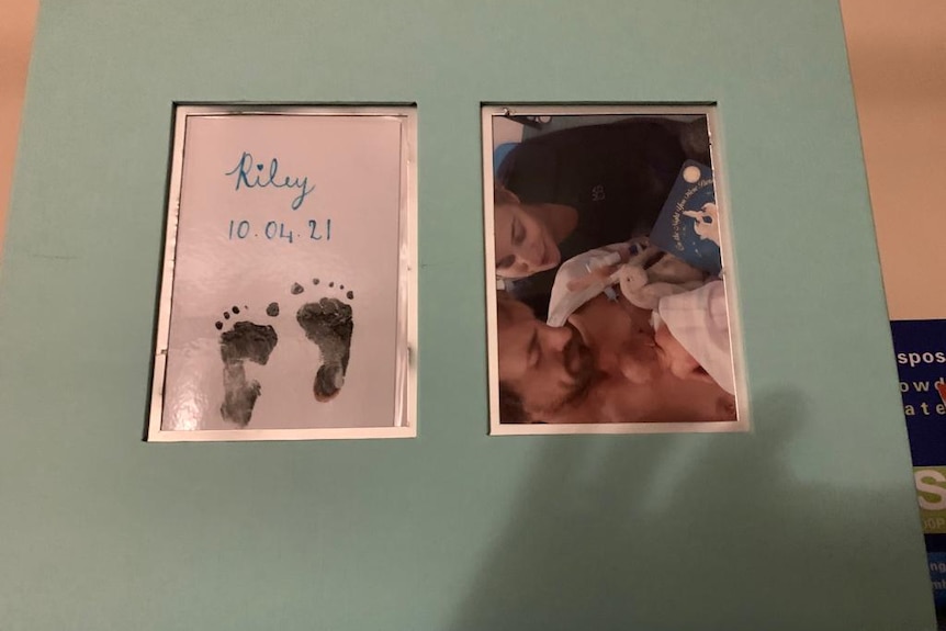 A framed image of baby footprints and a photograph of two parents holding a baby