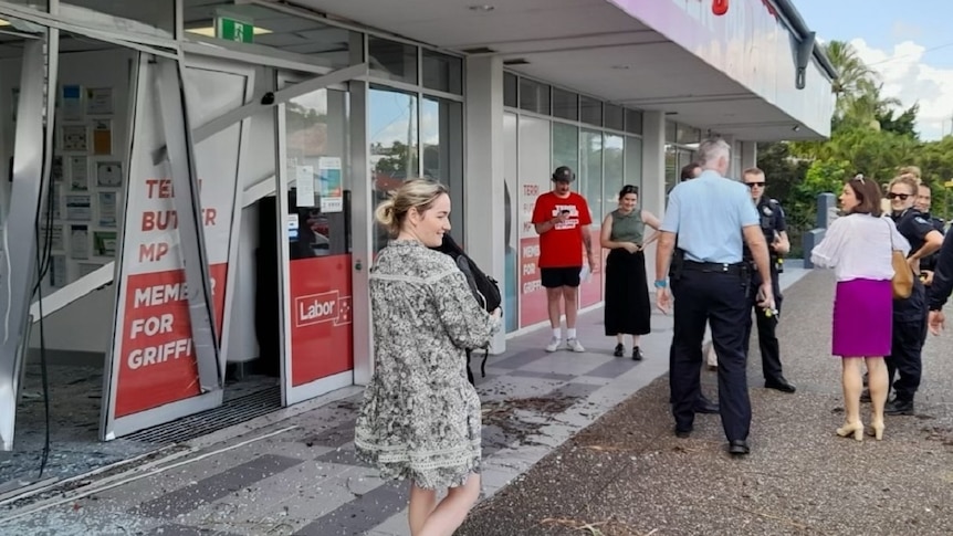 A group of police speaking to MP Terri Butler outside her damaged electorate office