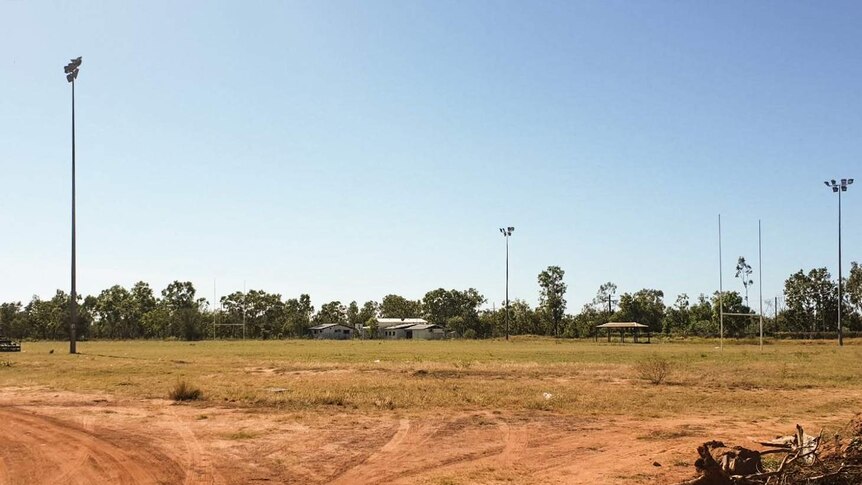 The Doomadgee football field, showing clear tyre marks and uneven grass.