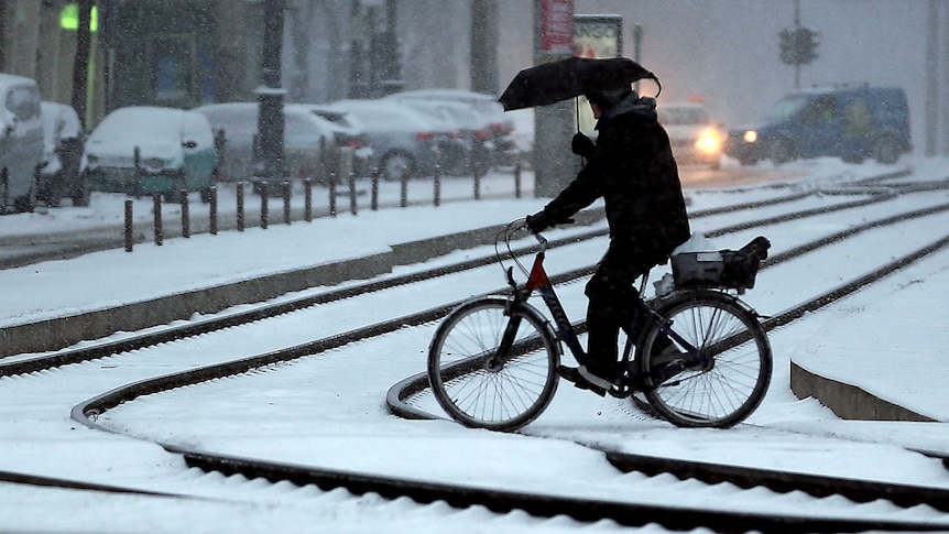 German cyclist crosses snow-covered road