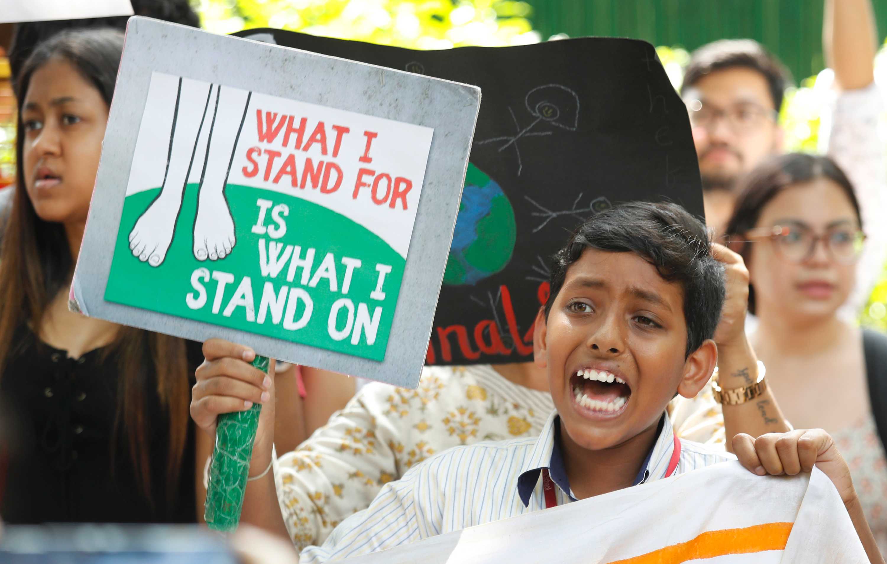 A young boy shouts slogans while holding a placard in New Delhi.