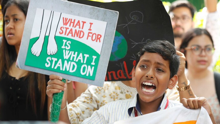 A young boy shouts slogans while holding a placard in New Delhi.