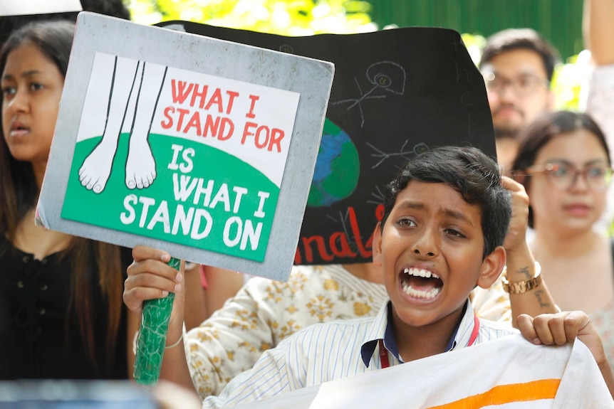 A young boy shouts slogans while holding a placard in New Delhi.