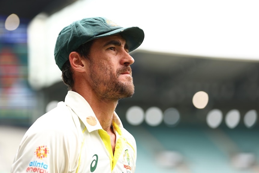 Mitch Starc purses his lips and looks out at the MCG