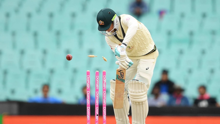Australia batsman Peter Handscomb plays a shot as a cricket ball hits his stumps on day four of the SCG Test against India.