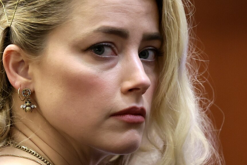 Amber Heard looking over her shoulder with a vulnerable expression on her face