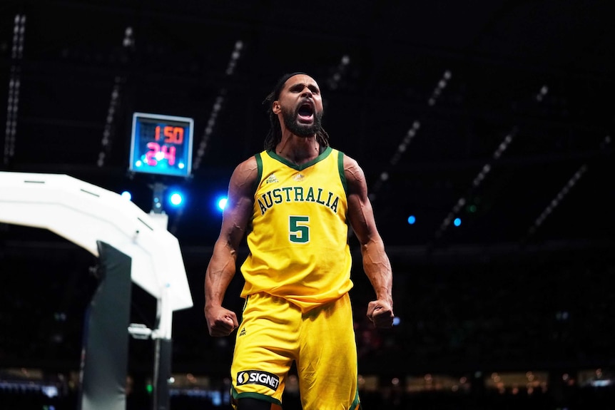 A male basketballer screams out as he celebrates winning a game.