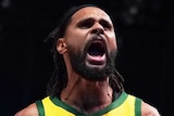 A male basketballer screams out as he celebrates winning a game.