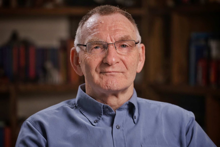 Hayden Cooper wears a blue collared shirt and glasses.