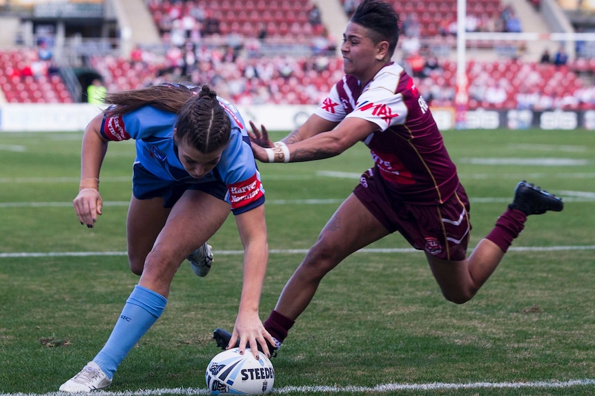 Jessica Stergis of NSW touches down for a try against Queensland.