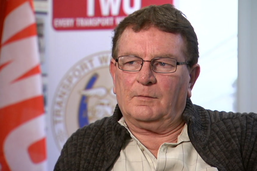 A close-up of a middle-aged man wearing glasses.