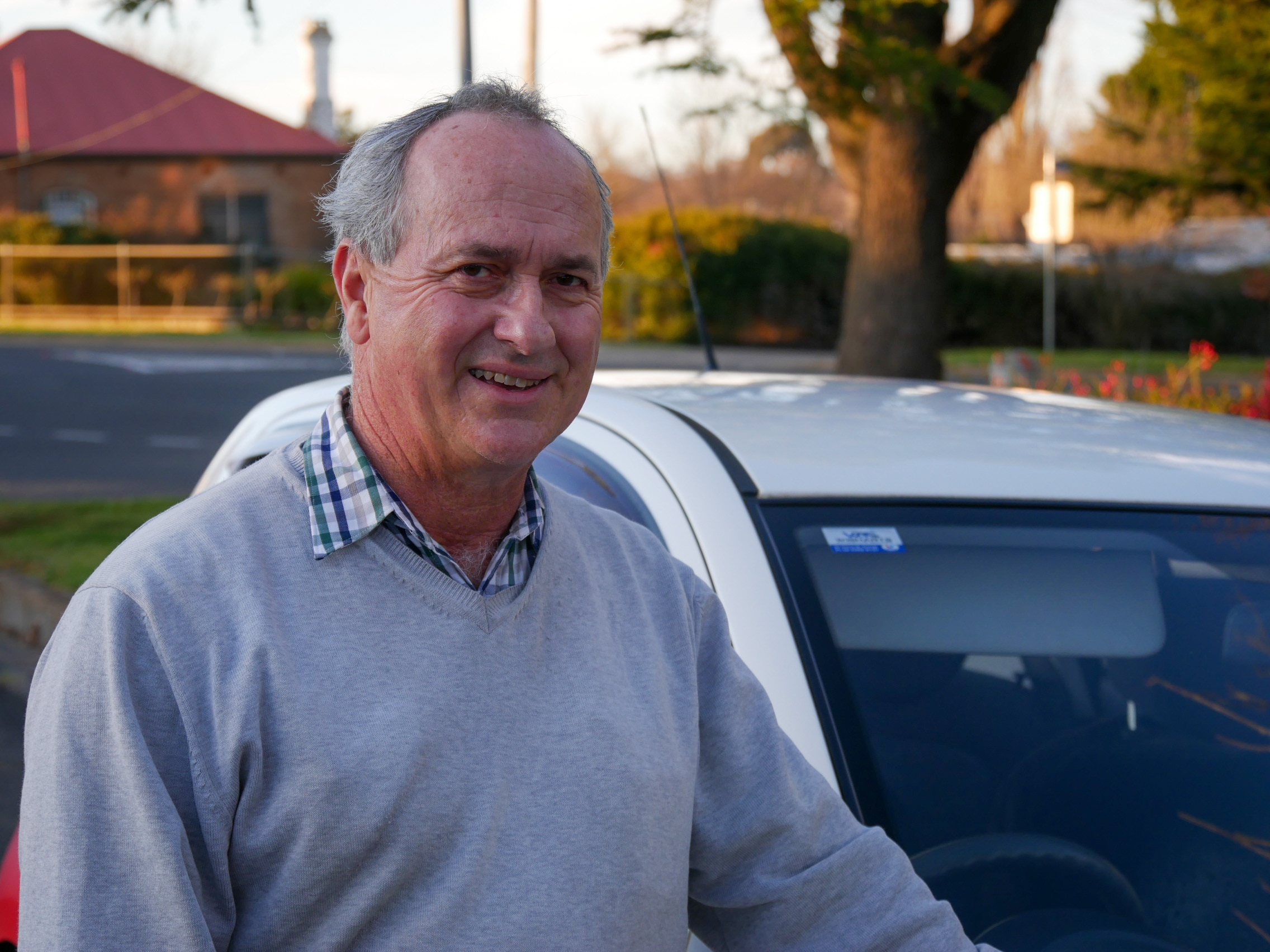 A man standing in front of a driving instructor's car