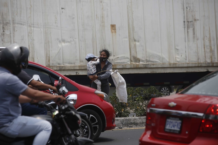 Leidy and her two-year-old son Leiton wave a white flag on la carretera al Pacifico in Villa Nueva, Guatemala, on 6 May 2020.