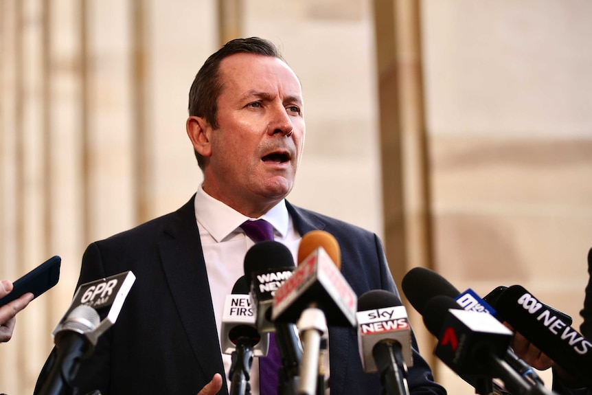 Mark McGowan give a press conference in front of several microphones