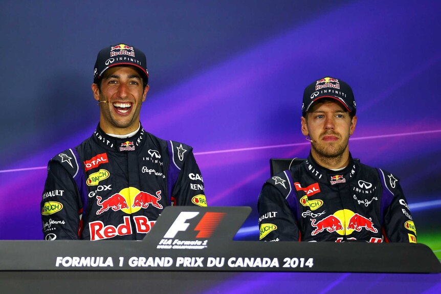 Daniel Ricciardo smiles as Sebastian Vettel looks on
