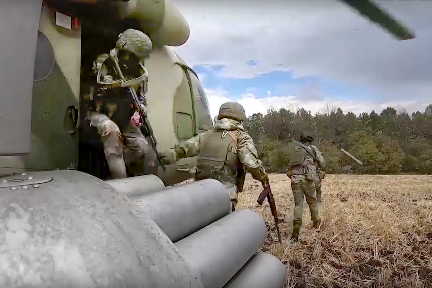 Russian Army soldiers leave a military helicopter during a mission at an undisclosed location in Ukraine.