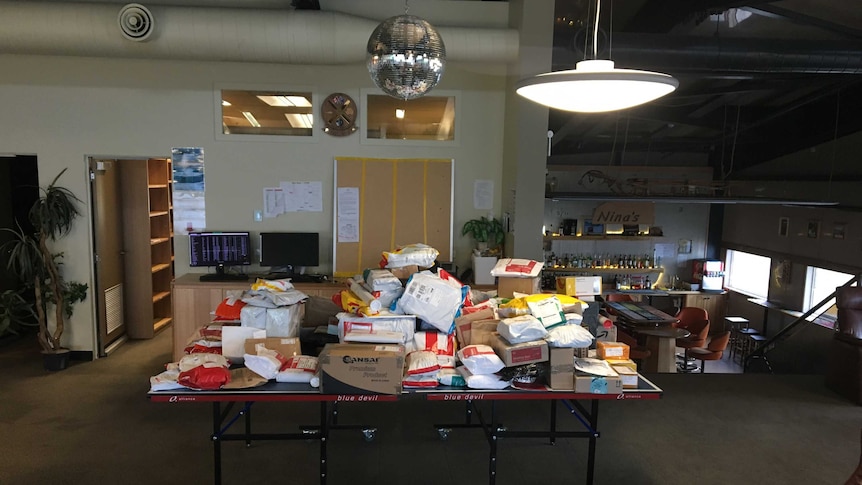 Piles of postage spread out on a table at a post office.