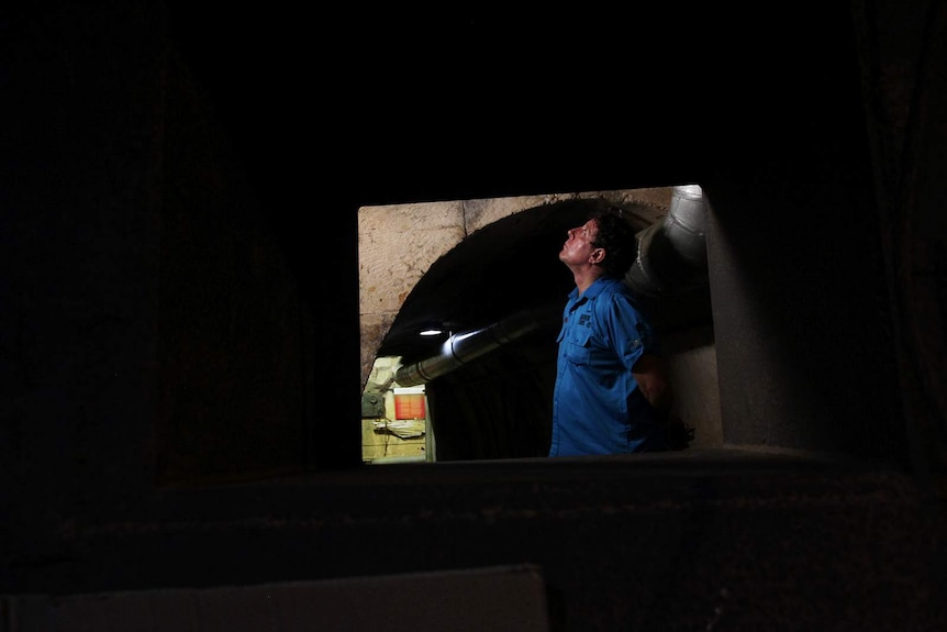 A photo of tourism operator Rob Marchant looking up from inside the oil tunnels.