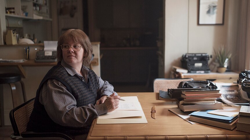 Colour still of Melissa McCarthy sitting at table writing in 2018 film Can You Ever Forgive Me?