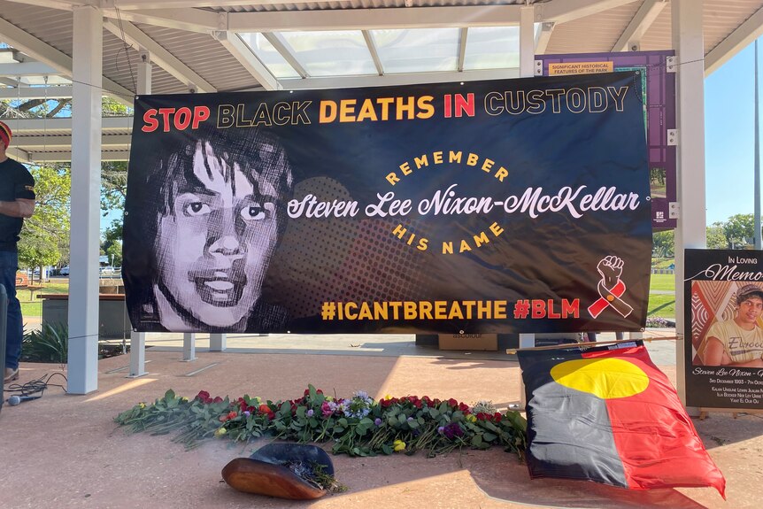 A banner bearing the face of a young Indigenous man who died in custody.