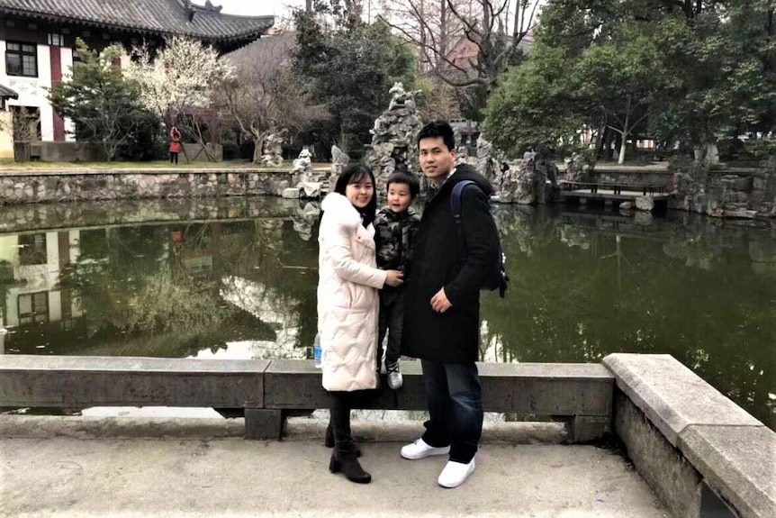 A young Chinese family posing for a photo.