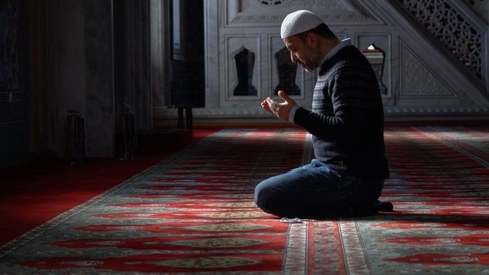 A Muslim man praying in a mosque