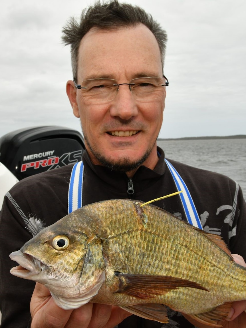 Fisherman Andrew Fleming holding a bream