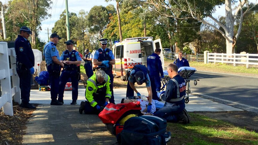 Police and paramedics around the man who was attacked by 3 dogs in Sydney's north-west