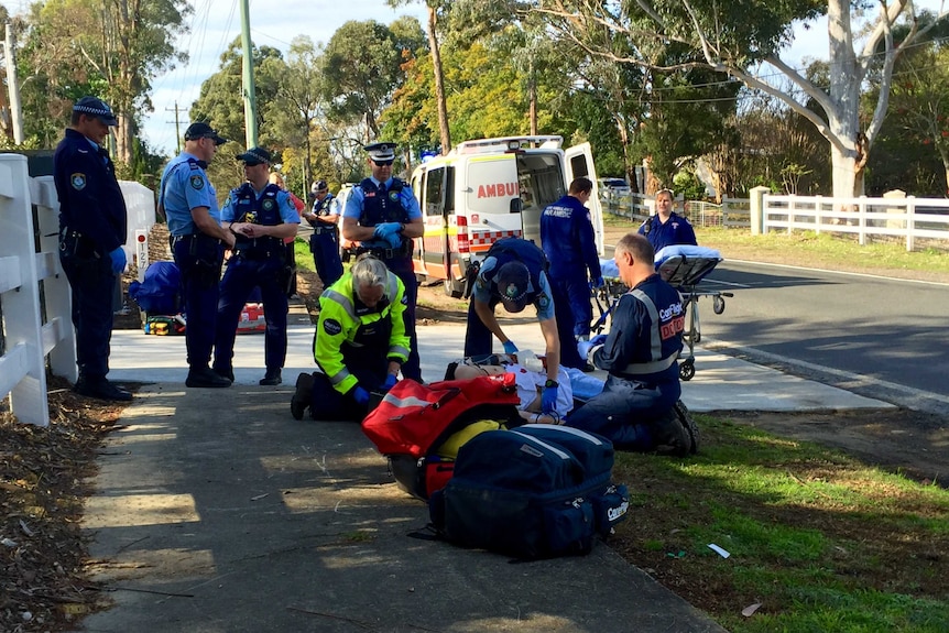 Police and paramedics around the man who was attacked by 3 dogs in Sydney's north-west