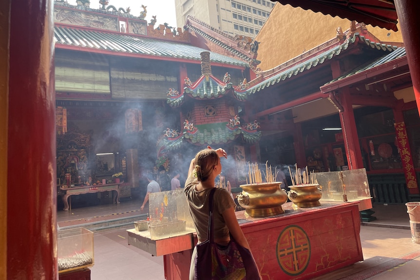 A woman with her back to the camera in an Asian temple